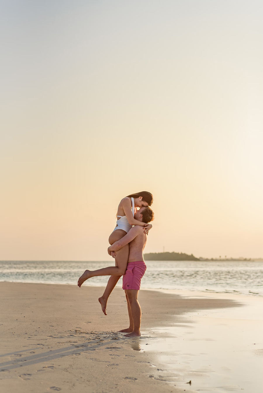 Premium Photo | A couple in love is walking on the beach near the sea young  family at sunset by the mediterranean sea summer vacation concept